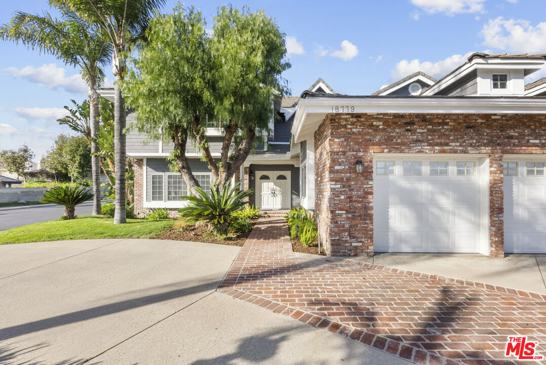 18779 Willowtree Lane Porter Ranch, CA 91326 - Photo 3 of 63 a front view of a house with a yard and garage