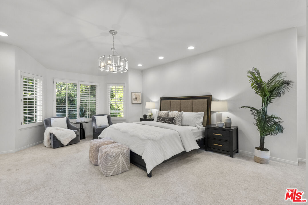 18779 Willowtree Lane Porter Ranch, CA 91326 - Photo 33 of 63 a spacious bedroom with a bed and a chandelier