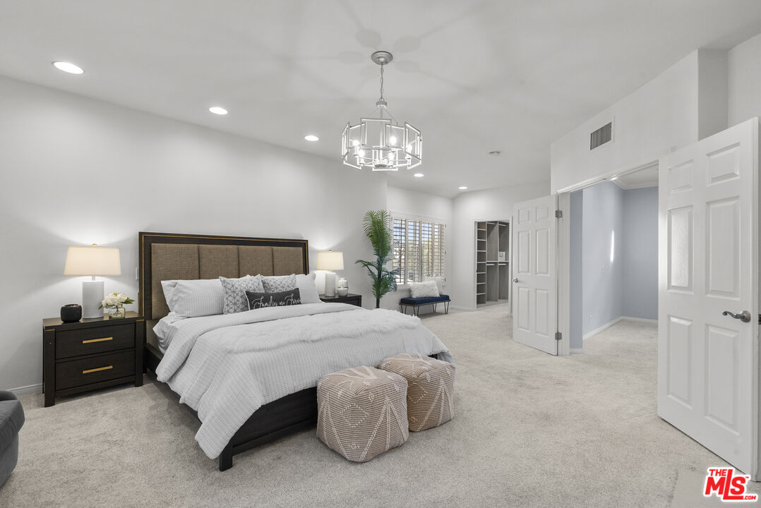 18779 Willowtree Lane Porter Ranch, CA 91326 - Photo 38 of 63 a spacious bedroom with a bed and a chandelier