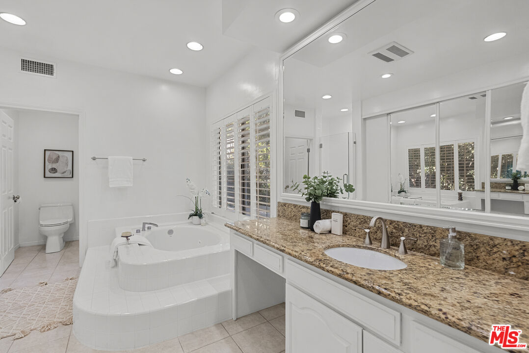 18779 Willowtree Lane Porter Ranch, CA 91326 - Photo 41 of 63 a bathroom with a granite countertop sink and a large mirror