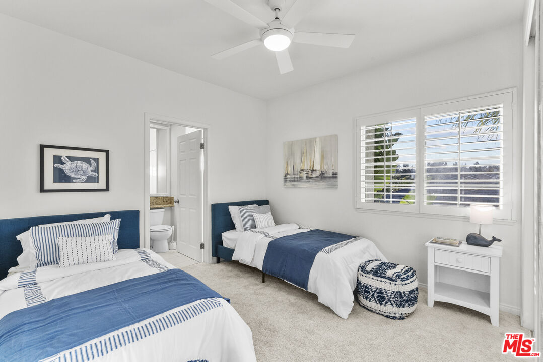 18779 Willowtree Lane Porter Ranch, CA 91326 - Photo 49 of 63 a spacious bedroom with a bed a couch and a window