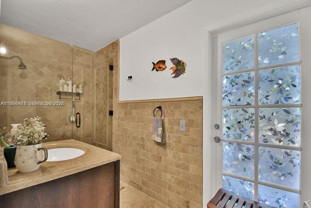 5425 Southwest 190th Avenue, Unit 1 Southwest Ranches, FL 33332 - Photo 11 of 56 a bathroom with a granite countertop sink a shower and a mirror
