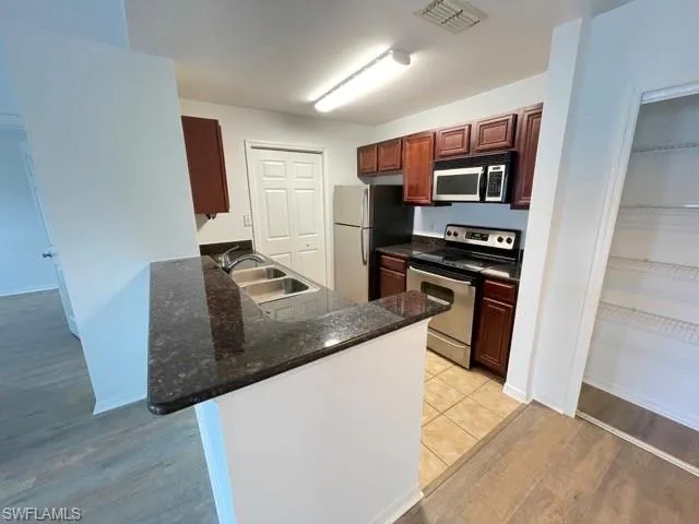 a kitchen with stainless steel appliances granite countertop a refrigerator and a stove