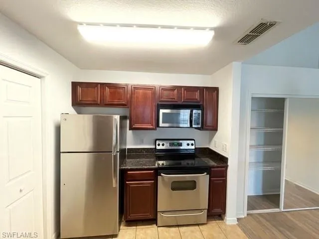 a kitchen with stainless steel appliances granite countertop a refrigerator and a stove