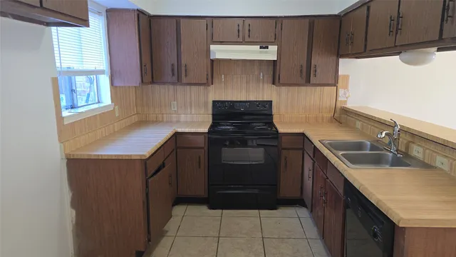 a kitchen with a sink stove and cabinets