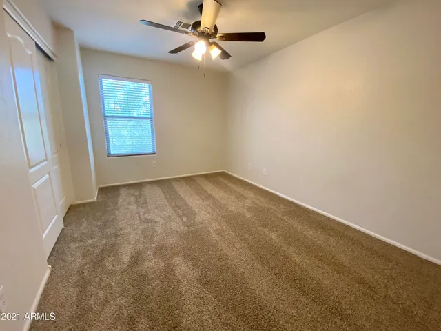 an empty room with windows and fan