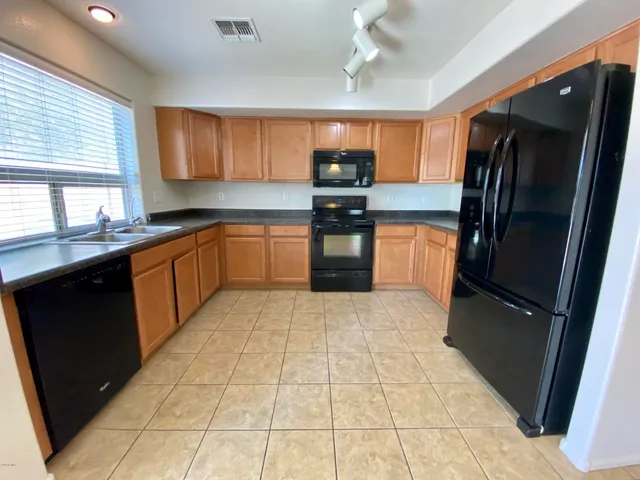 a kitchen with stainless steel appliances granite countertop a refrigerator and a sink