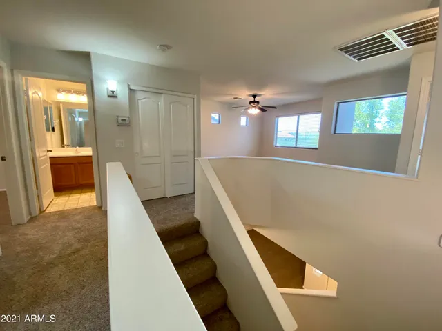 a view of a hallway with furniture and chandelier