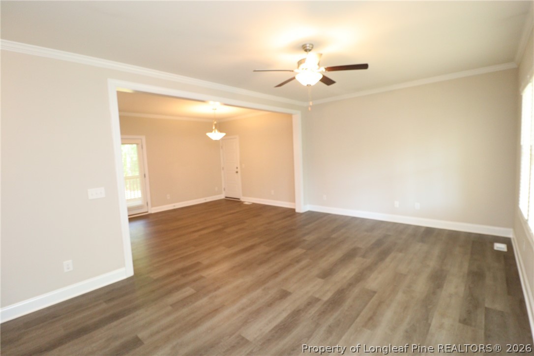 8424 Rhodes Road Apex, NC 27539 - Photo 3 of 31 an empty room with wooden floor fan and window
