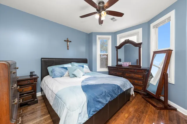 a bedroom with a bed a chandelier and dresser