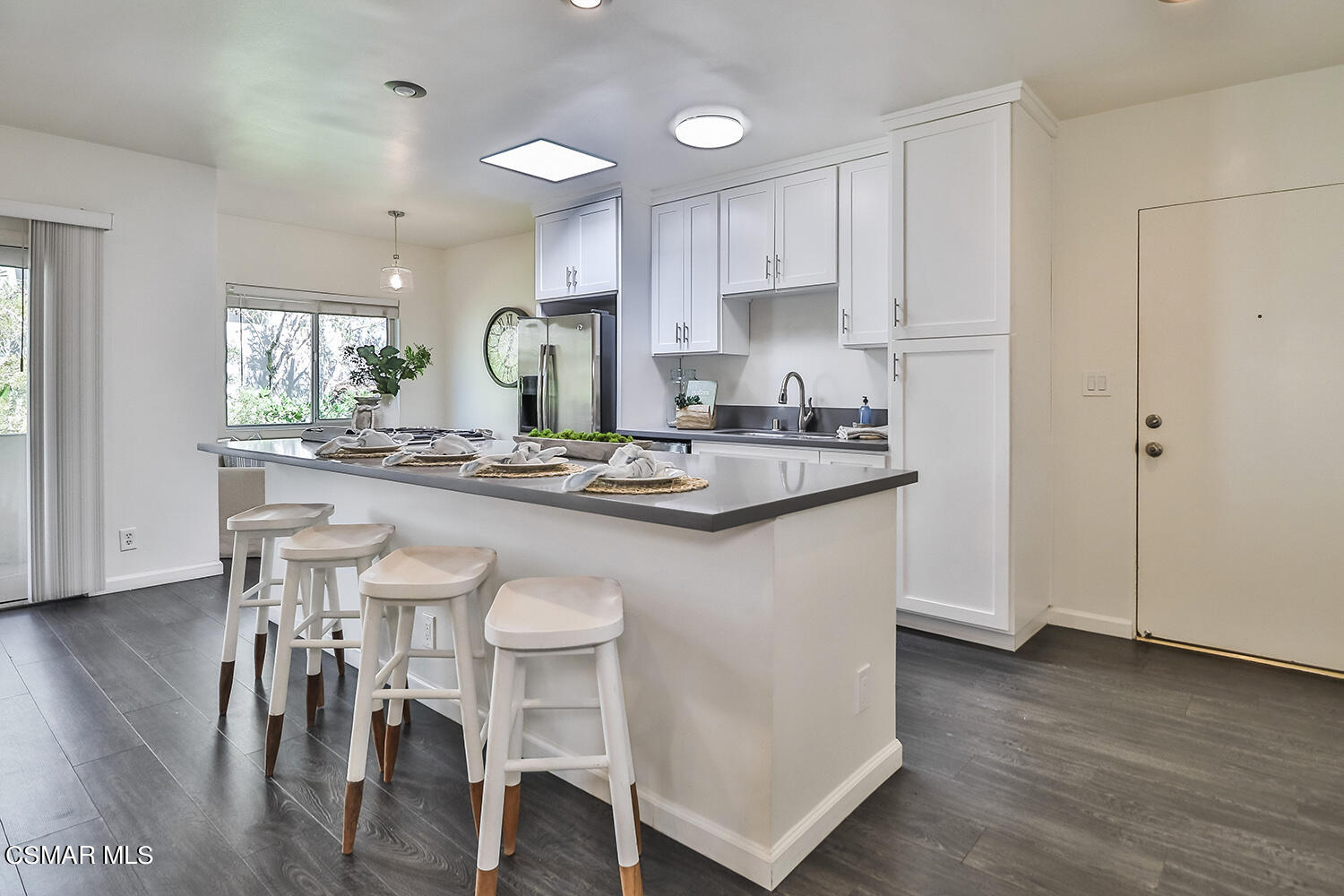 844 16th Street, Unit 5 Santa Monica, CA 90403 - Photo 6 of 31 a kitchen with kitchen island granite countertop a sink cabinets and wooden floor