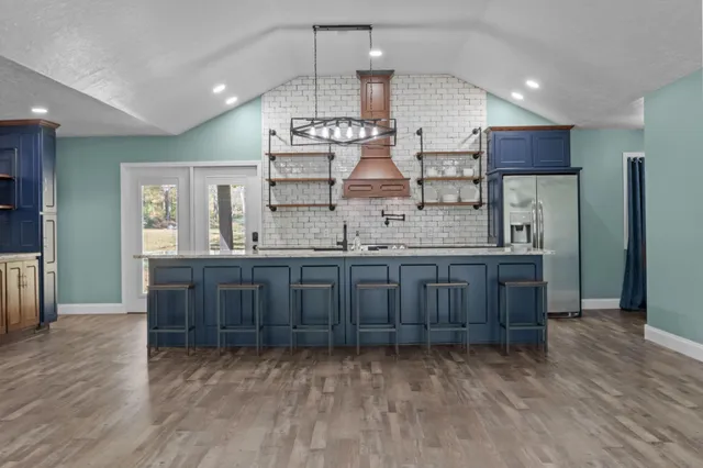 a kitchen with stainless steel appliances granite countertop a refrigerator and a stove top oven