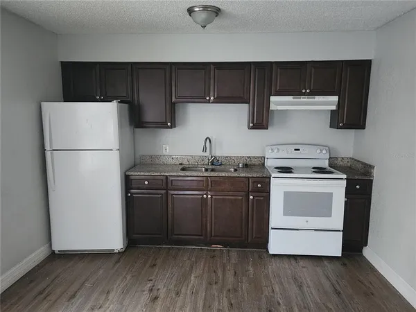 a kitchen with a sink a refrigerator and cabinets
