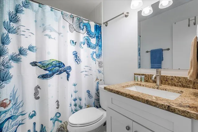 a bedroom with a bed and flat tv screen on the dresser