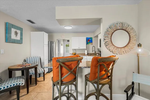 a kitchen with stainless steel appliances granite countertop a stove top oven a sink a dining table and chairs