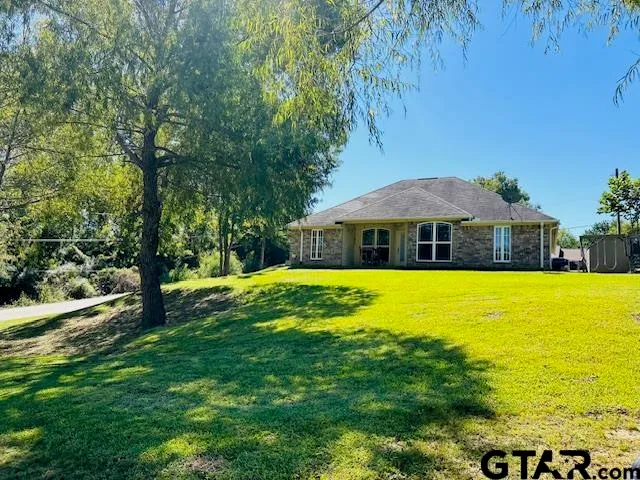 a view of a swimming pool with lawn chairs under an umbrella