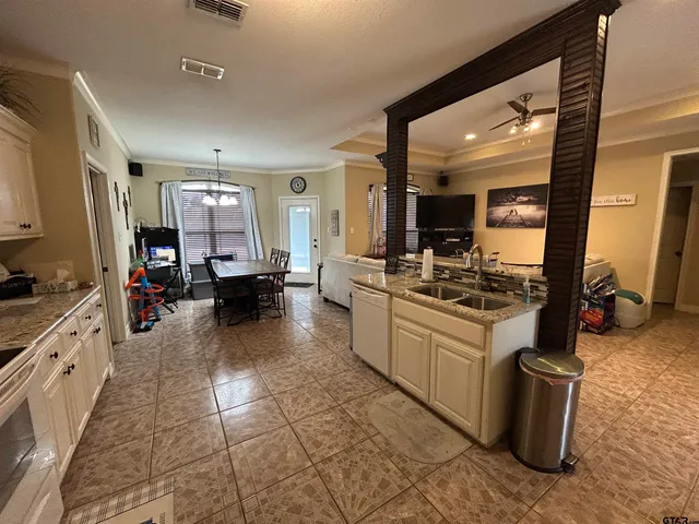 a large white kitchen with kitchen island a stove a sink and a refrigerator