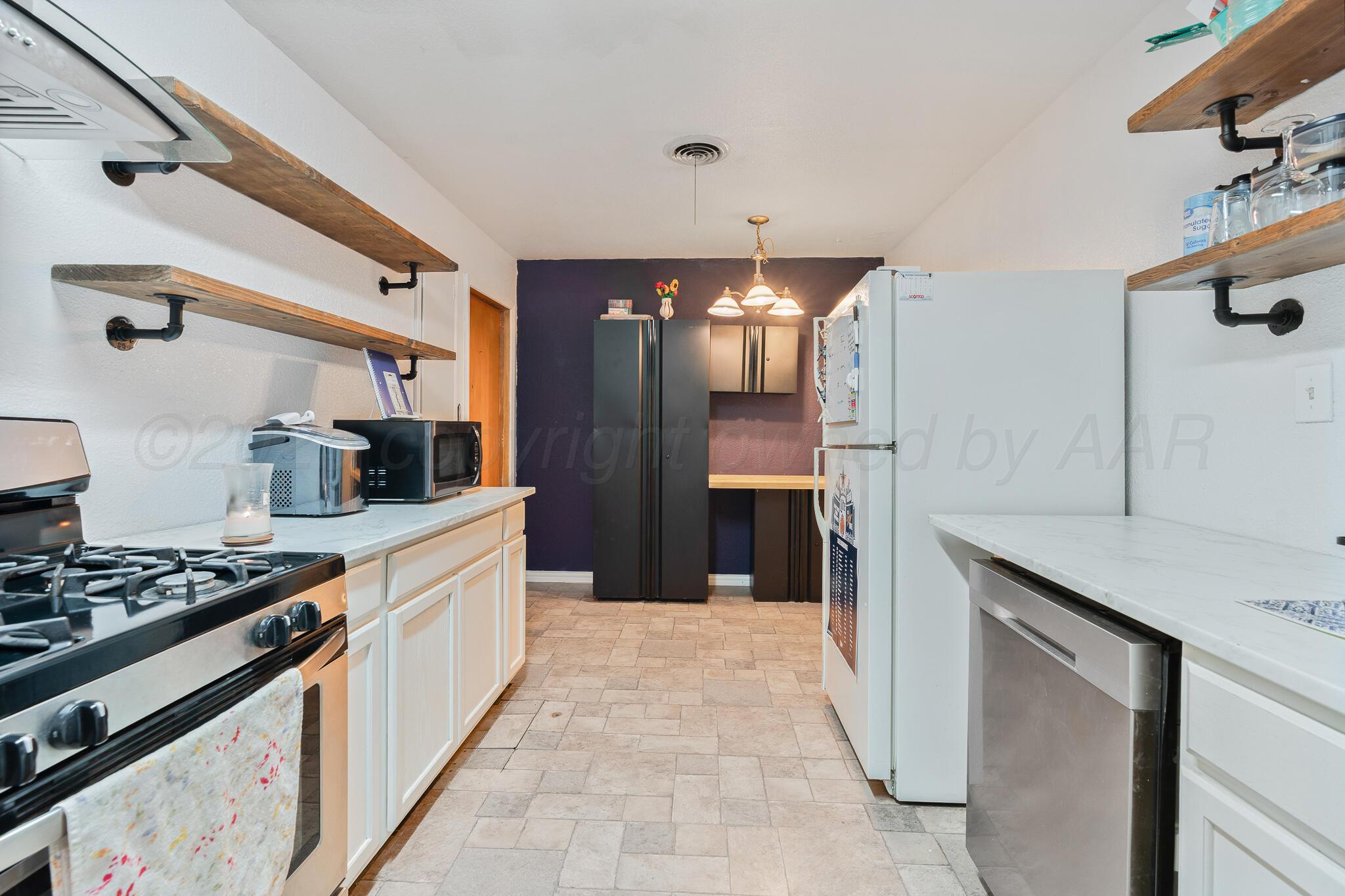 1814 Magnolia Street Amarillo, TX 79107 - Photo 12 of 26 a kitchen with stainless steel appliances a sink stove and refrigerator