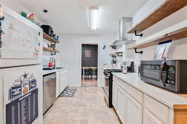 a kitchen with stainless steel appliances granite countertop a stove and cabinets