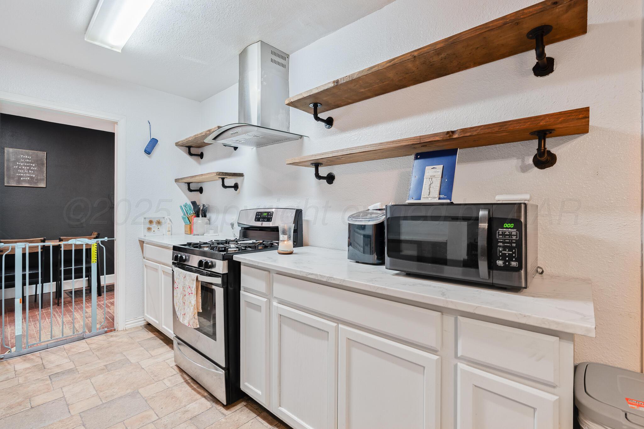 1814 Magnolia Street Amarillo, TX 79107 - Photo 15 of 26 a kitchen with stainless steel appliances a stove a microwave and a hard wood floor
