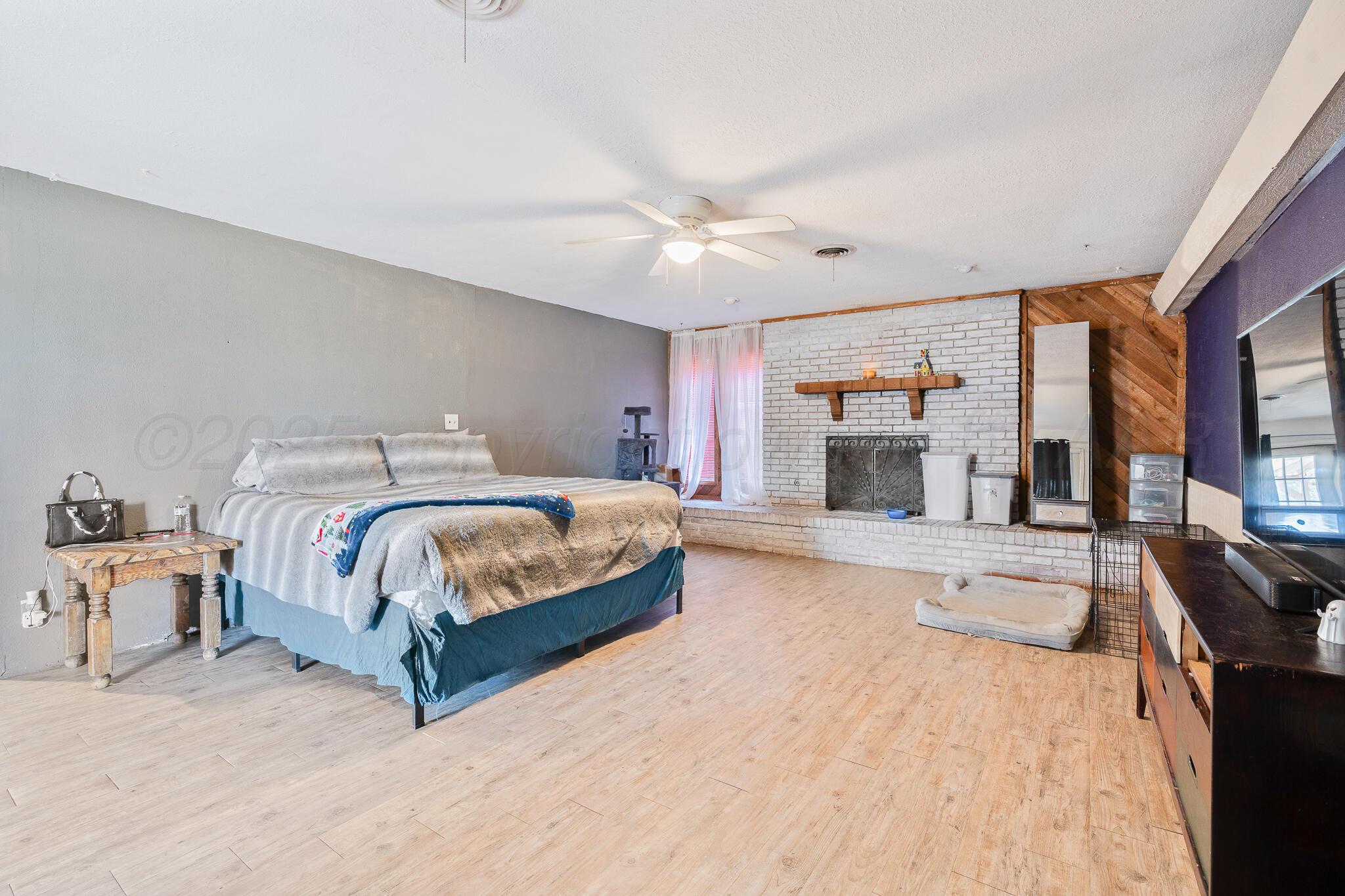 1814 Magnolia Street Amarillo, TX 79107 - Photo 20 of 26 a bedroom with a large bed and a chandelier