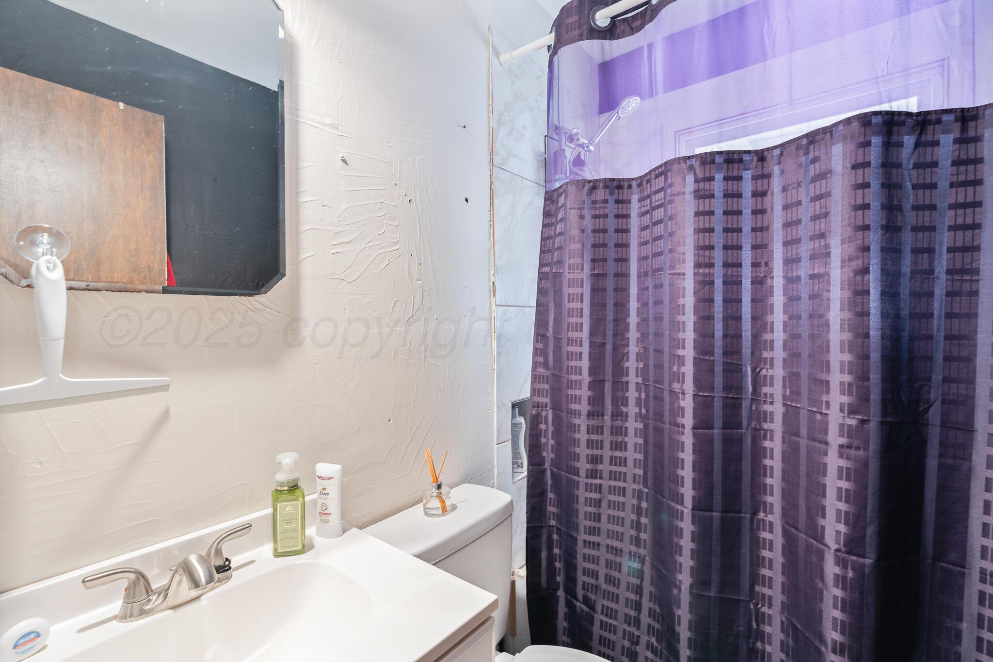 1814 Magnolia Street Amarillo, TX 79107 - Photo 21 of 26 a bathroom with a sink and a mirror