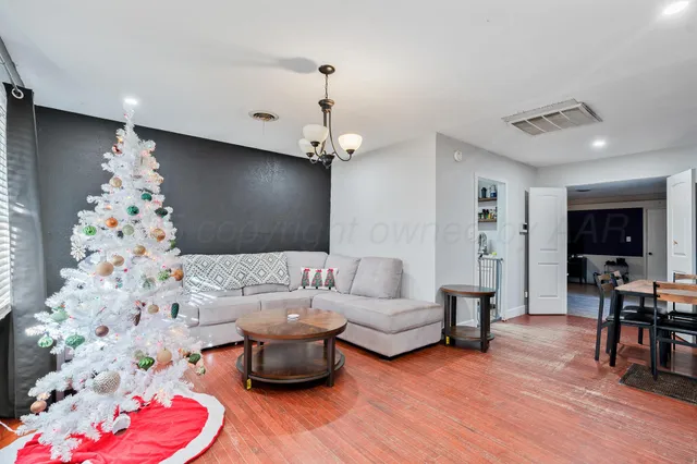 a living room with furniture and wooden floor