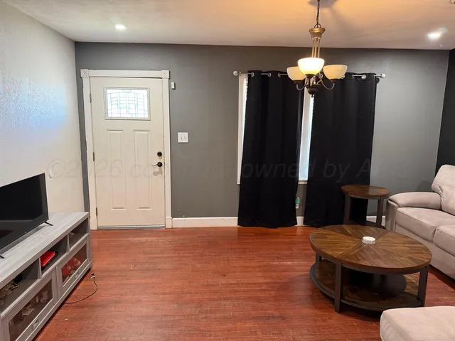 an empty room with furniture and a flat screen tv