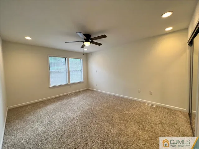 an empty room with a ceiling fan and a window