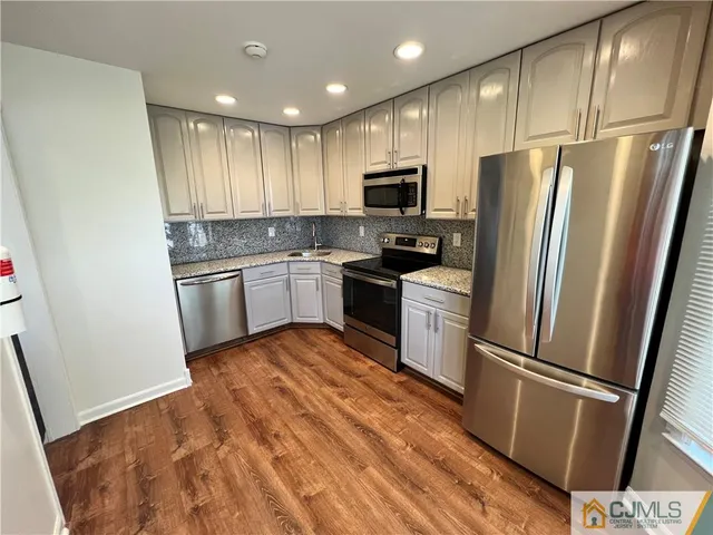 a kitchen with stainless steel appliances a refrigerator sink and microwave