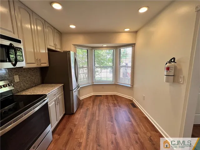 a kitchen with a refrigerator and a stove top oven