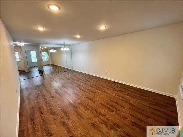 a view of a hallway view with wooden floor and chandelier
