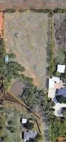 a view of a tree in a field of the house