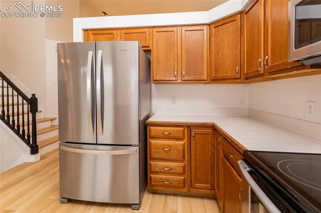 a kitchen with stainless steel appliances granite countertop a refrigerator and a stove top oven