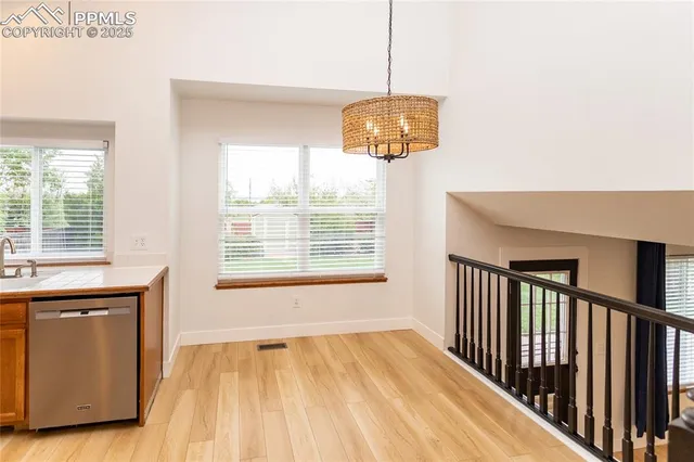 a view of a room with a chandelier and wooden floor