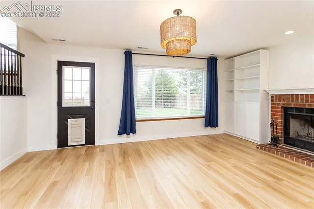 a view of an empty room with window and a fireplace