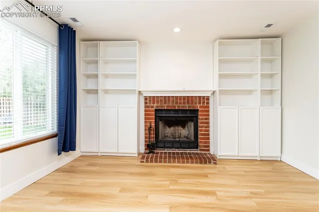 a view of a livingroom with a fireplace and window