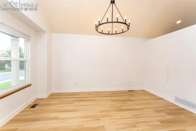 a view of wooden floor and chandelier in a room
