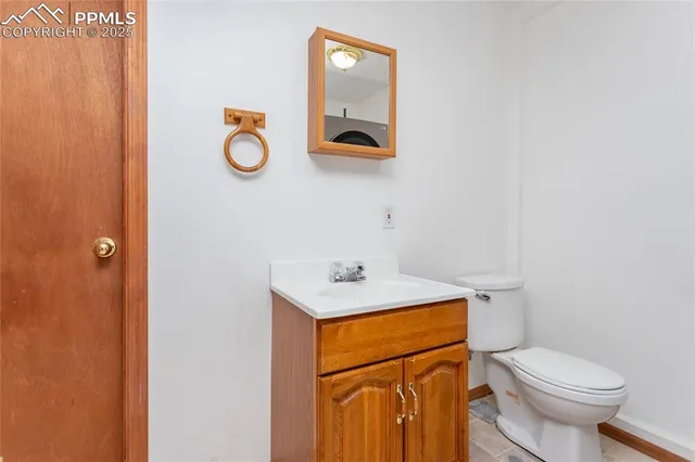 a bathroom with a toilet sink vanity and mirror