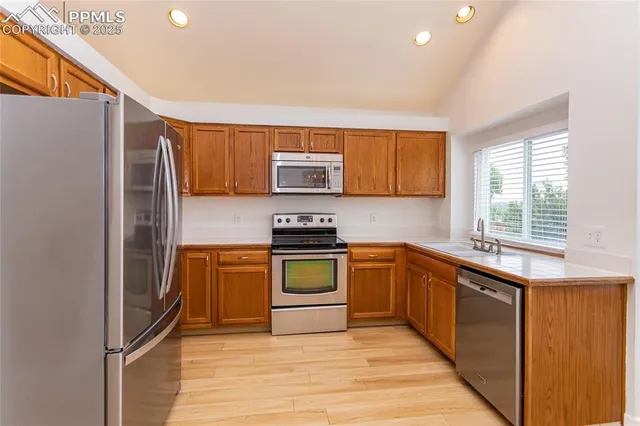 a kitchen with granite countertop a refrigerator and a stove top oven