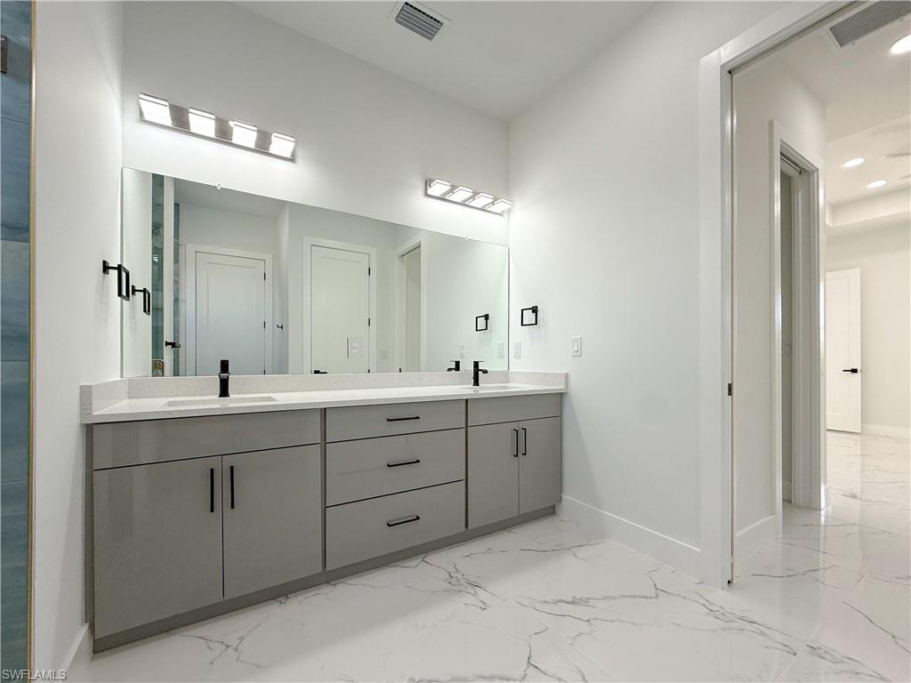 436 Rathburn Street Lehigh Acres, FL 33974 - Photo 11 of 22 Bathroom featuring double vanity, light marble finish flooring, and recessed lighting