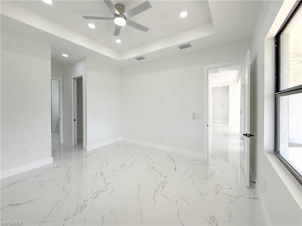 436 Rathburn Street Lehigh Acres, FL 33974 - Photo 14 of 22 Unfurnished room featuring recessed lighting, a tray ceiling, a ceiling fan, and light marble finish flooring
