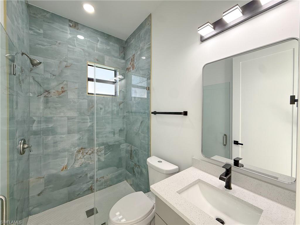 436 Rathburn Street Lehigh Acres, FL 33974 - Photo 16 of 22 Bathroom featuring vanity and a shower stall