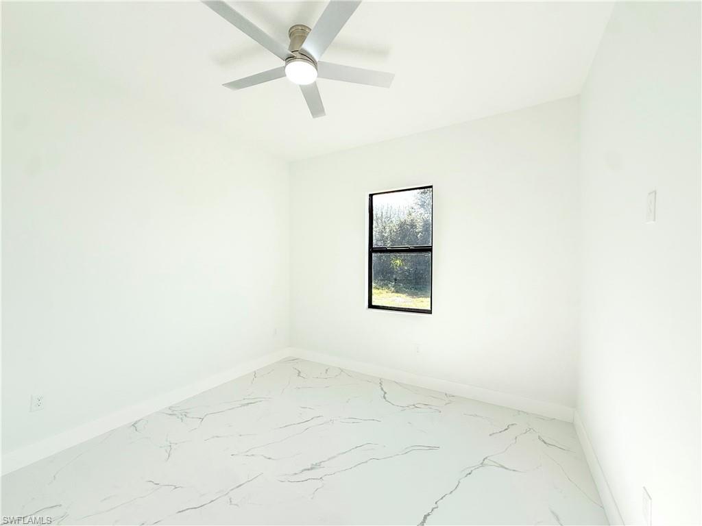 436 Rathburn Street Lehigh Acres, FL 33974 - Photo 17 of 22 Unfurnished room with light marble finish flooring and ceiling fan