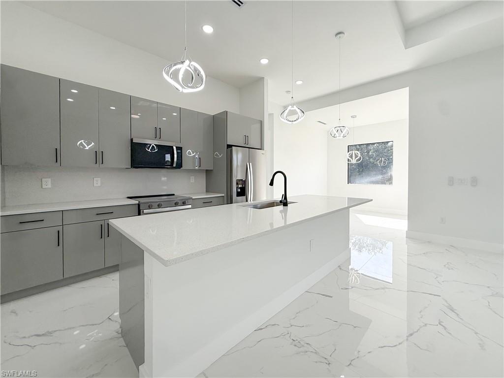 436 Rathburn Street Lehigh Acres, FL 33974 - Photo 19 of 22 Kitchen featuring gray cabinetry, decorative light fixtures, a kitchen island with sink, appliances with stainless steel finishes, and recessed lighting