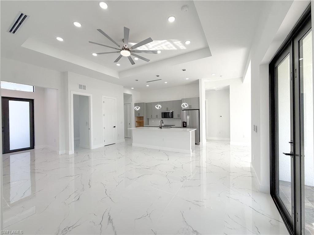 436 Rathburn Street Lehigh Acres, FL 33974 - Photo 20 of 22 Unfurnished living room featuring recessed lighting, a raised ceiling, light marble finish floors, and a ceiling fan