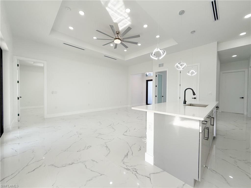 436 Rathburn Street Lehigh Acres, FL 33974 - Photo 4 of 22 Kitchen with a kitchen island with sink, pendant lighting, recessed lighting, light stone countertops, and light marble finish floors