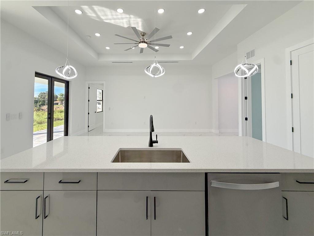 436 Rathburn Street Lehigh Acres, FL 33974 - Photo 5 of 22 Kitchen with hanging light fixtures, recessed lighting, dishwasher, light stone countertops, and french doors