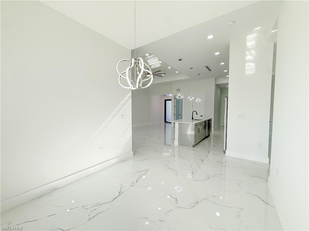 436 Rathburn Street Lehigh Acres, FL 33974 - Photo 6 of 22 Unfurnished dining area with recessed lighting, a chandelier, and light marble finish floors
