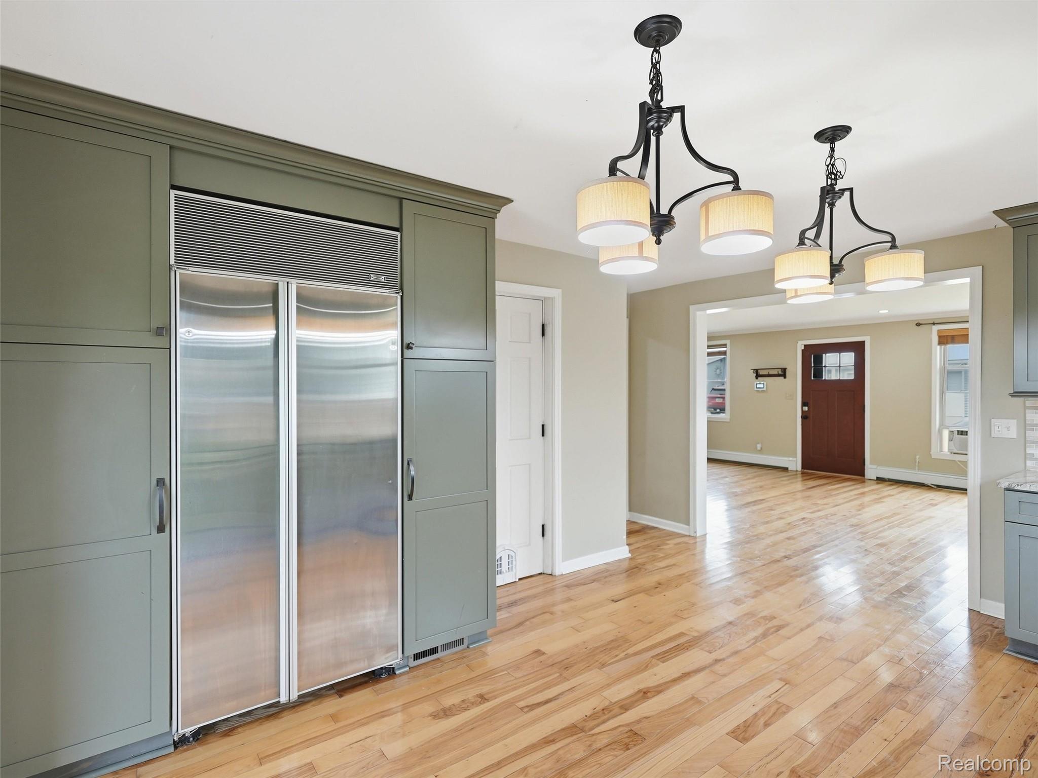 117 Kenyon Road Algonac, MI 48001 - Photo 21 of 47 Kitchen area featuring integrated stainless steel refrigeration, custom green cabinetry with crown molding, and wood-finish flooring
